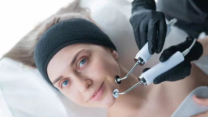 A young woman having the best microcurrent facial device treatment 
